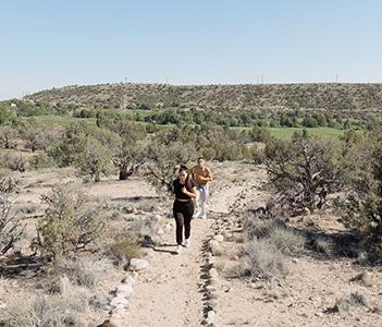 两名跑步者在沙漠风景中有标记的户外小路上