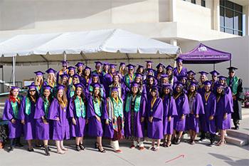 一群戴着毕业帽、身穿毕业服的SJC梅里恩奖学金毕业生站在一起，面带微笑